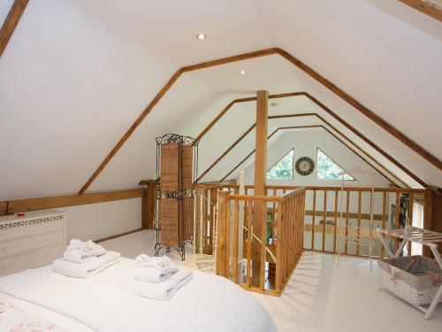 a attic room with a bed and a staircase at The Barn in Burley