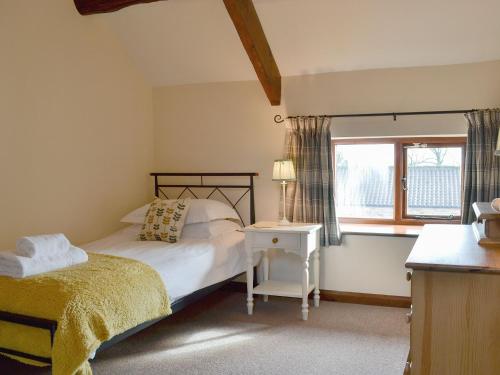 a bedroom with a bed and a window at Ash Tree Cottage in Gillamoor