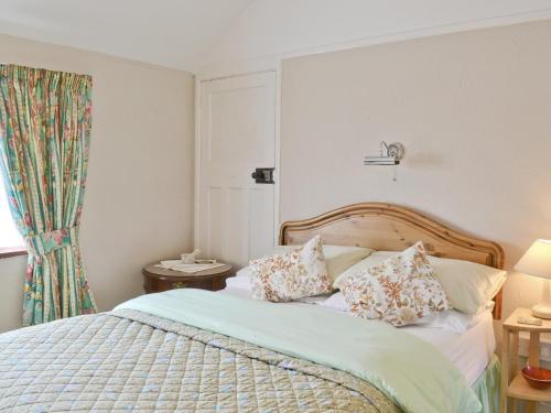 a bedroom with a bed with pillows and a window at Heath View Cottage in Westleton