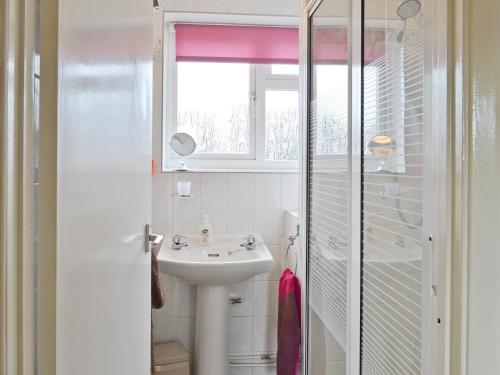 baño con lavabo y ventana en Heath View Cottage en Westleton