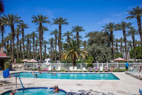 una piscina en un complejo con palmeras en Palm Springs Camping Resort Loft Cabin 1, en Palm Desert