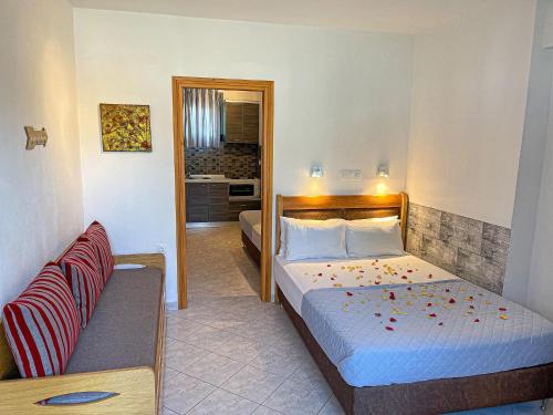 ein Schlafzimmer mit zwei Betten und einem Sofa darin in der Unterkunft Bella Mare Villa Sithonia in Akti Salonikiou