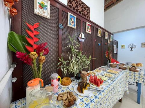 una mesa larga con platos de comida. en Pousada Alecrim Dourado, en Paraty