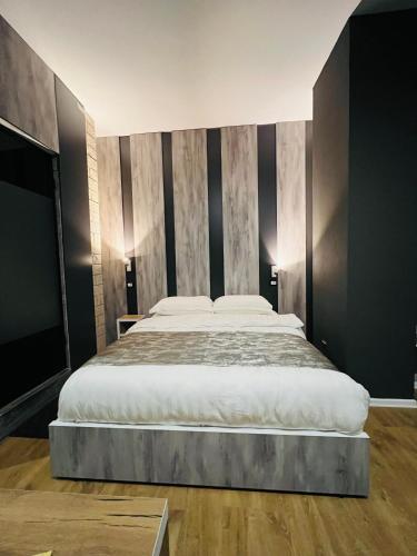 a large bed in a bedroom with black walls at Colombia Apartments&Rooms in Durrës