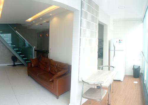 ein Wohnzimmer mit einem Sofa und einem Tisch in der Unterkunft Cobertura duplex, com duas suítes e piscina in Cabo Frio