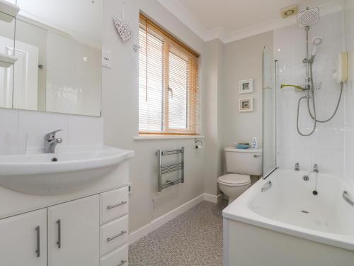 a white bathroom with a sink and a toilet at Oyster Cottage in Falmouth