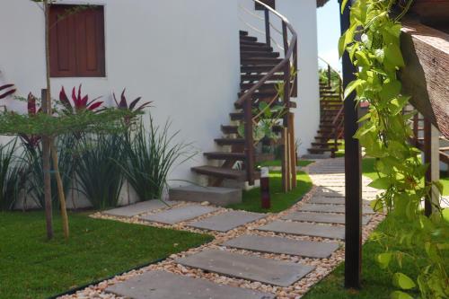 a garden with a stone path leading to a house at Oka Pousada Atins in Atins