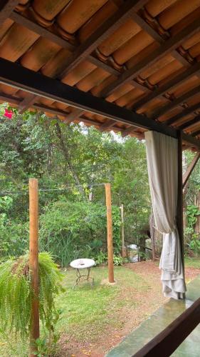 a view of a patio with a table and a curtain at Pousada Canto Feliz in Serra do Cipo