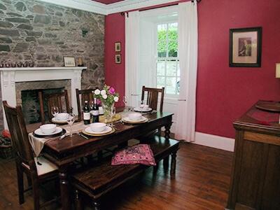 a dining room with a table and a fireplace at The Cottage in Garlieston