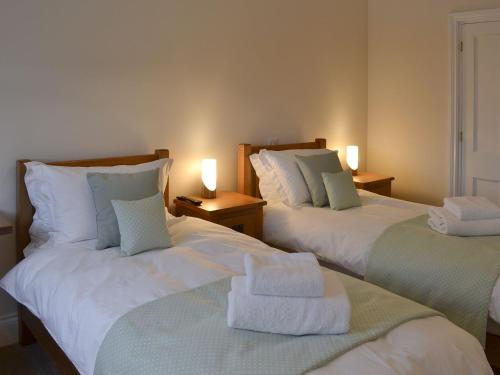 1 dormitorio con 2 camas y toallas. en Park Farm Cottage en Folkton