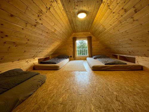 a room with two beds in a wooden cabin at Nature Center Údolí volavek II in Weseritz