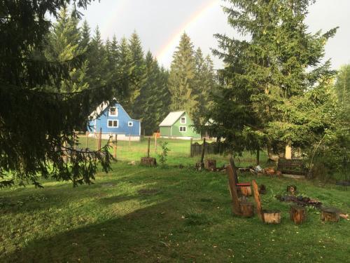 un groupe de maisons dans un champ avec arc-en-ciel dans l'établissement Nature Center Údolí volavek II, à Weseritz