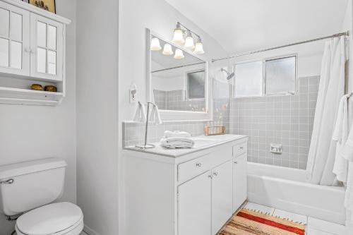 a white bathroom with a toilet and a sink at Casa Mesa in Santa Barbara