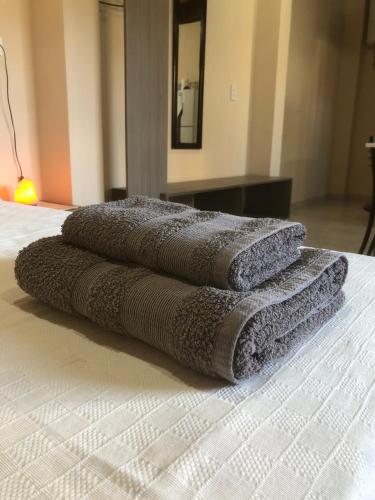 three towels sitting on top of a bed at Venezia-Monoambiente in Villa Mercedes