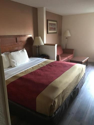 a hotel room with a large bed and a couch at The Best Inn & Suites in Markham