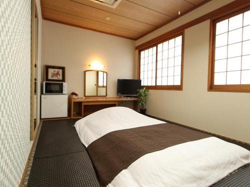 Un pat sau paturi într-o cameră la HOTEL LiVEMAX BUDGET Okinawa Tomariko