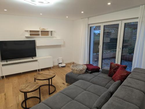 a living room with a couch and a flat screen tv at foxxbau - urlaubswohnen im Saarschleifenland in Merzig