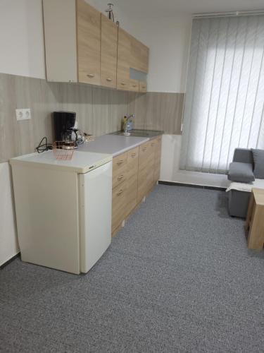 a kitchen with a white refrigerator and a couch at Imperial exclusive apartments in Velika Kladuša
