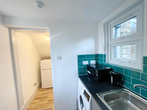 a small kitchen with a sink and a window at 2 Bed Gem Margate, Free Parking in Kent