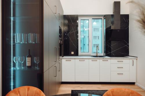 een keuken met witte kasten en een zwarte koelkast bij Fabulous and Fancy City Center Designer Apartment in Cluj-Napoca