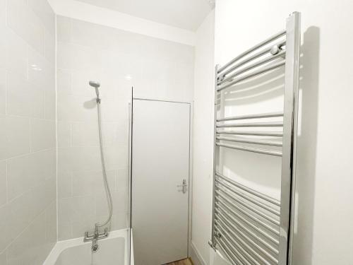 a white bathroom with a shower and a toilet at Margate 2 Bed, Prime Location in Kent