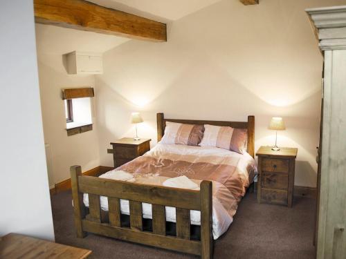 a bedroom with a bed and two night stands at Hutter Hill Barn West in Silsden