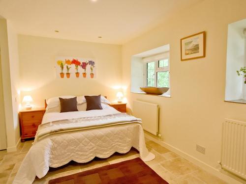 a bedroom with a bed and two lamps and a window at Spring Cottage - Hw7734 in Tintern