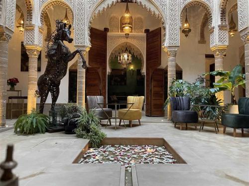 eine Lobby mit einer Statue in der Mitte eines Gebäudes in der Unterkunft Riad AL Bahi in Rabat