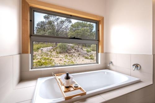 a bath tub in a bathroom with a window at Wild Sanctuary in Bicheno