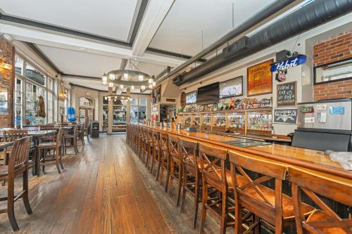 un bar en un restaurante con mesas y sillas de madera en The Bedford Regency Hotel, en Victoria