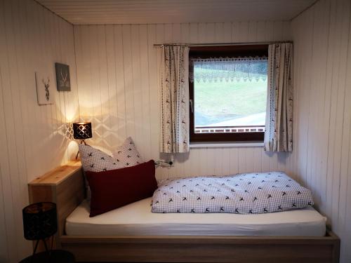 een kleine slaapkamer met een bed en een raam bij Erwin's in Bildstein