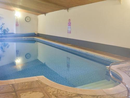 a large swimming pool in a room at Barn Owl in Ipplepen