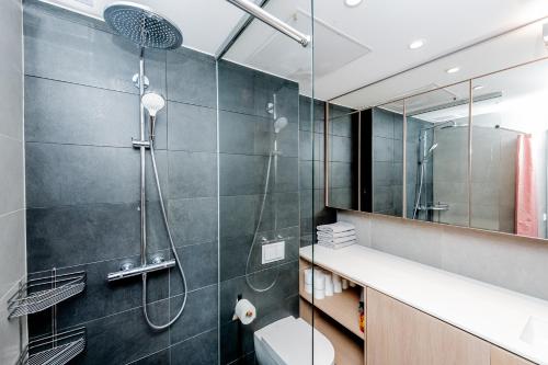 a bathroom with a shower and a toilet and a sink at Heart of Pärnu Living - Contemporary 2 Bedroom Apartment with Balcony & Parking in Pärnu