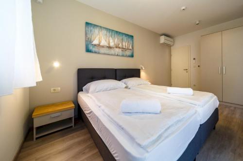ein Schlafzimmer mit einem großen Bett mit weißer Bettwäsche in der Unterkunft Luxury Villa Loma 2 in Sveti Vid-Miholjice