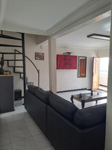 a living room with a black couch and a table at Casa Djoko in Dakar