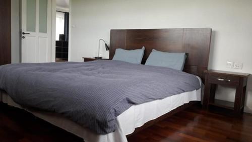 a bedroom with a large bed with a wooden headboard at Jags villa in Plaine Magnien
