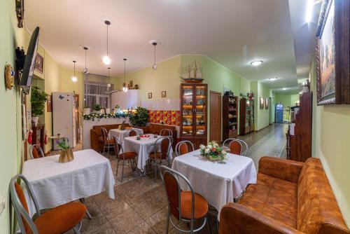 a restaurant with two tables and a couch and chairs at Танаис мини-отель in Saint Petersburg