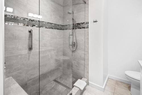 uma casa de banho com um chuveiro e uma porta de vidro em Corazon Luxury Suite by IRIS PROPERTIES! em Victoria