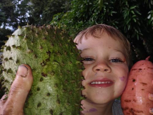 a young child is holding up a durian at Finca Mystica in Mérida
