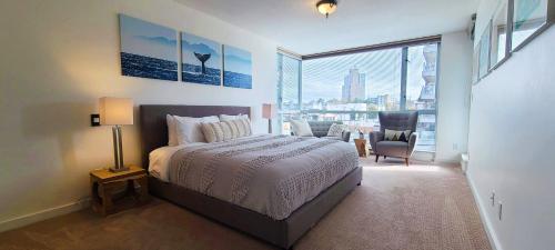 a bedroom with a bed and a large window at Corazon Oasis by IRIS PROPERTIES! in Victoria