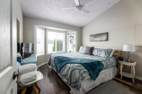 a bedroom with a bed and a ceiling fan at Seascape Beach House by IRIS PROPERTIES! in Sooke