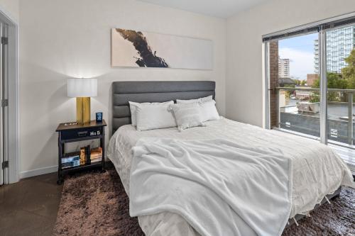 a white bedroom with a bed and a window at Soho Penthouse by IRIS PROPERTIES! in Victoria