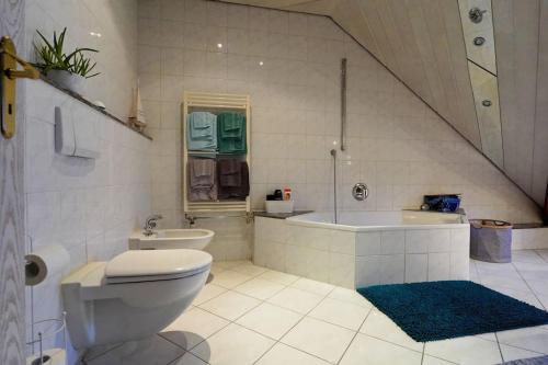 a bathroom with a toilet and a tub and a sink at Große, helle Wohnung für bis zu 6 Personen in Weinheim