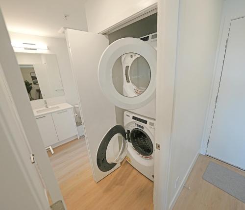 a laundry room with a washer and dryer at The Belmont by IRIS PROPERTIES! in Victoria