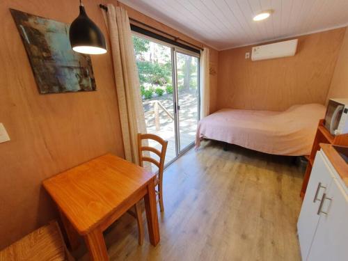 Habitación pequeña con cama, mesa y escritorio. en Helles, modernes Containerhaus, en Punta del Este