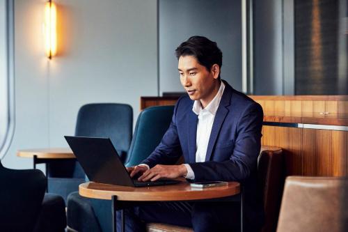 a man sitting at a table using a laptop computer at Hyatt Regency Sydney in Sydney