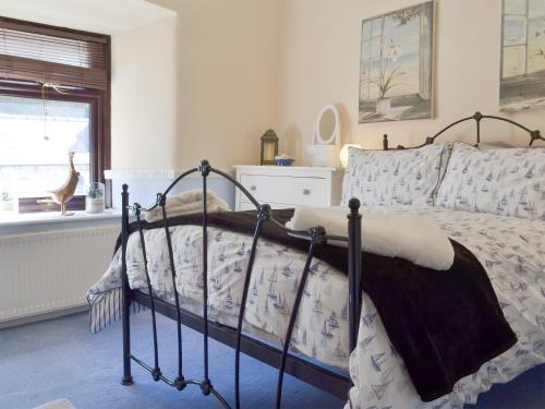 a bedroom with a bed and a window at Poppy Cottage in Bonsall