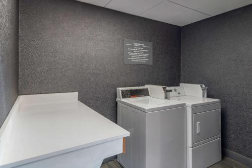 a laundry room with a washing machine and a counter at Best Western Plus Dalton Inn in Dalton