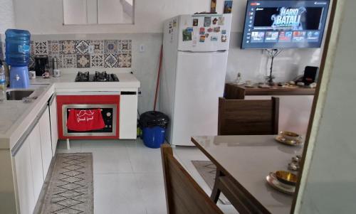 ブジオスにあるcasa com piscina e churrasqueira adoravelのキッチン(コンロ、白い冷蔵庫付)