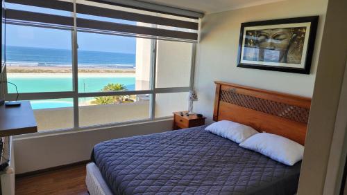 1 dormitorio con 1 cama y vistas al océano en Laguna del mar La Serena. departamento, en La Serena